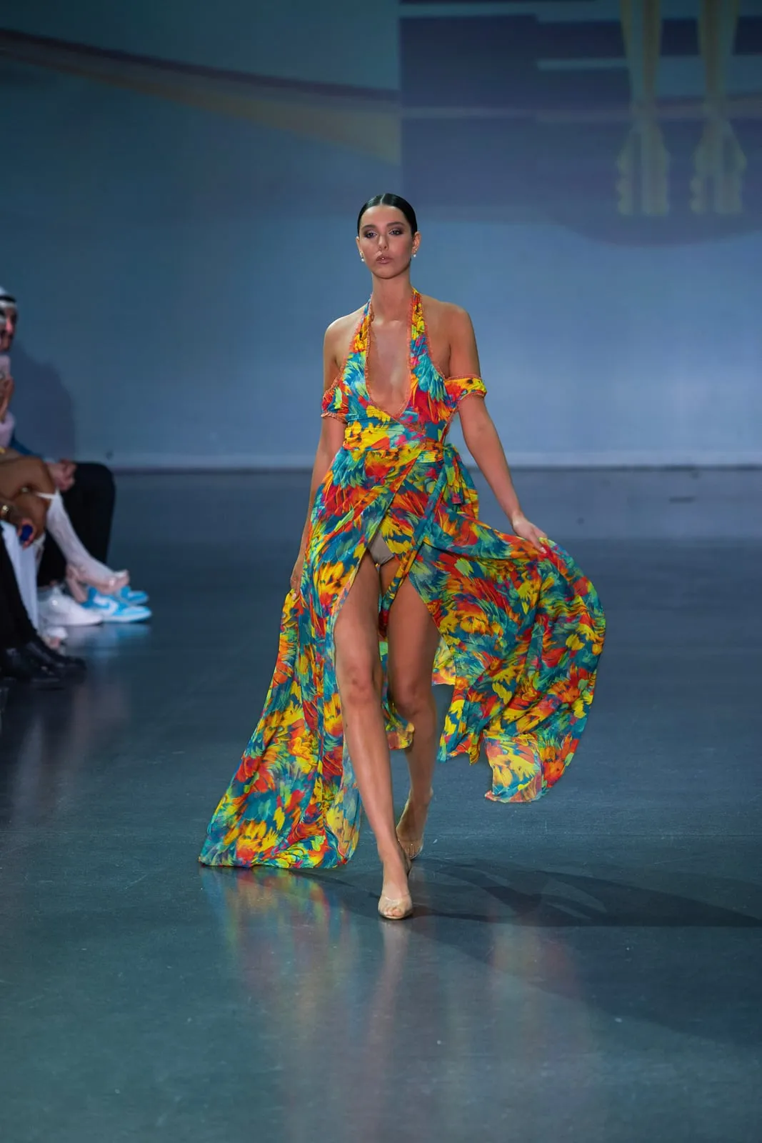 A model in a floral cover-up and bikini walking the runway