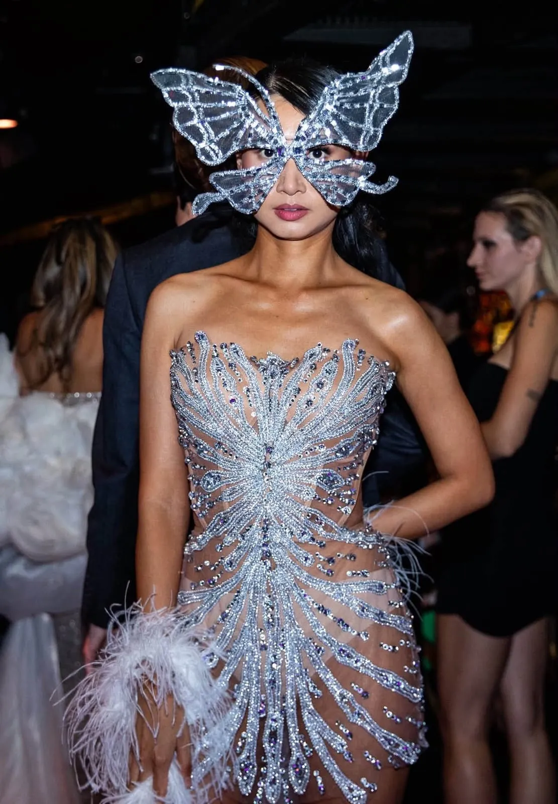 A model in a crystal-embellished corset and a crystal butterfly mask backstage