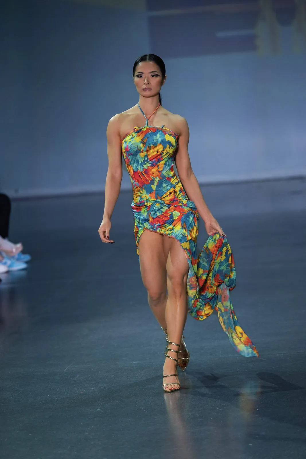 A model in a bright floral cover-up walking the runway